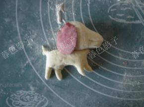 红曲粉揉一点点的彩色面做耳朵。沾点水组合三个部位。耳朵只要粘上边就好。