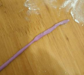 取小块紫色面团，搓成小条。(紫色面团做法:直接拿第一步混合好的面粉加一点紫薯和成面团就可以了，因为用的不多)