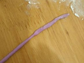 取小块紫色面团，搓成小条。(紫色面团做法:直接拿第一步混合好的面粉加一点紫薯和成面团就可以了，因为用的不多)