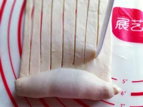 再长舌状面皮的另一端从下往上卷起来，卷到一半时停下来，再用水果刀切出条状，请看图。
