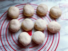 将排气松弛好的面团分割成8等份，约75g，盖上保鲜膜松弛10分钟。