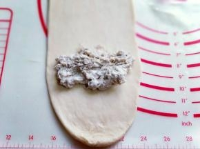 再放上肉松馅。(也可以把肉松馅平铺，和面团一起擀成长舌状，根据个人喜欢来。)