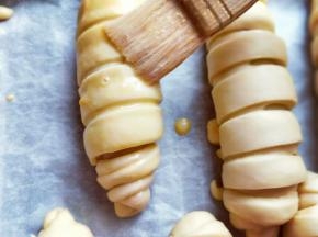 发酵好的面包胚取出全部刷上蛋液。再撒上黑芝麻，可以送入烤箱。