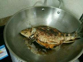 热锅凉油下鲤鱼和姜片，再撒适量盐。煎至两面金黄盛出备用。