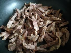 将切好的牛肉条放入平底锅中，小火慢炒，将水份炒干。