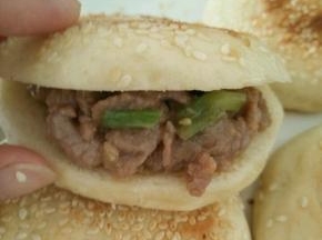 取个烧饼，用刀切开，不要切断。把牛肉塞进去。