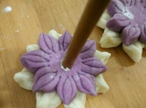 用一根筷子先沾点水再沾芝麻，轻轻压在花的中心。全部做好再饧半小时入锅蒸15分钟焖五分钟出锅。