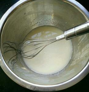 玉米油和牛奶混合，搅打至乳化。筛入低筋面粉和奶粉，翻拌均匀。