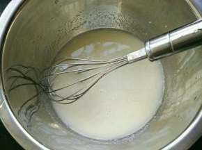 玉米油和牛奶混合，搅打至乳化。筛入低筋面粉和奶粉，翻拌均匀。