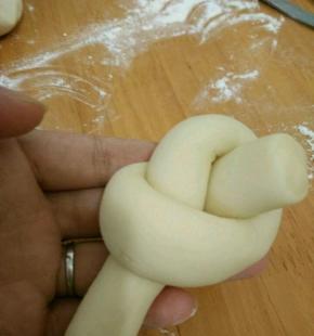 把其中一端转个圈，然后端头从中间穿出来。