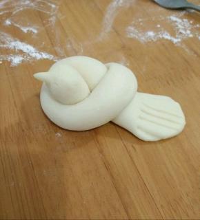 然后捏出小鸟的嘴巴，尾巴用剪刀修剪一下，再用叉子压出纹路。