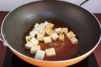 豆腐放在手上切块，入锅；