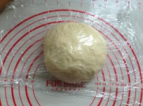 发酵好后的面团，取出轻拍排气，滚圆，盖上保鲜膜松驰15分钟