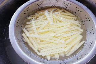 把土豆条清水洗去淀粉，再浸泡几分钟，冲去淀粉沥干备用