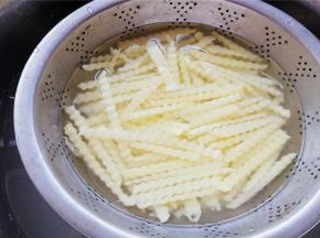 把土豆条清水洗去淀粉，再浸泡几分钟，冲去淀粉沥干备用