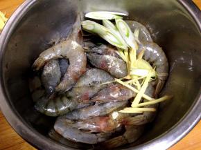 大虾入盆加盐、料酒、白胡椒粉、一半的葱、姜丝抓匀腌制20分钟