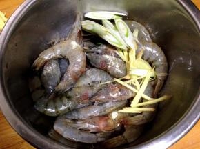 大虾入盆加盐、料酒、白胡椒粉、一半的葱、姜丝抓匀腌制20分钟