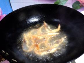 锅内加适量食用油烧至八成热，分次下入大虾炸至变色捞出备用