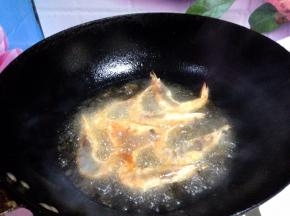 锅内加适量食用油烧至八成热，分次下入大虾炸至变色捞出备用