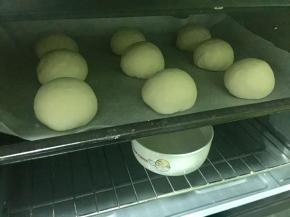 把豆沙包放进烤箱，同时放入一碗热水增加温度和湿度，进行二次发酵。