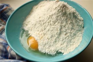 现在开始做疙瘩。一个鸡蛋打入碗里，再加入200克左右的面粉，这个分量够2到3个人份。