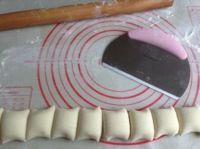 取出，在揉面垫上排气，搓成长条，切成11等份