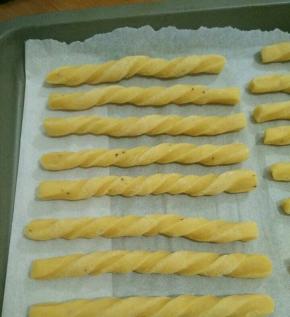 用手抓住两头，反方向拧几圈，摆在烤盘里。