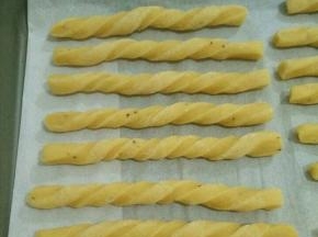 用手抓住两头，反方向拧几圈，摆在烤盘里。