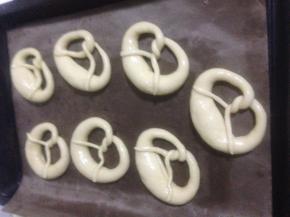 泡好取出的面包胚挨个摆在烤盘里 垫高温油布或者油纸 不要直接放在金盘上  醒一会 喜欢暄软口感的可以多醒一会 割口 撒上海盐