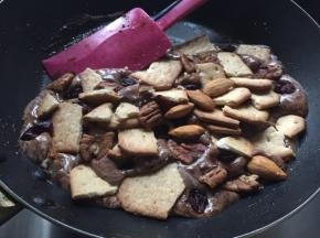 倒入稍掰碎的饼干、果仁和果干充分搅拌混合均匀，动作要快，避免棉花糖降温后变硬
