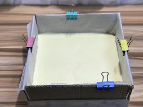 倒入面糊，刮平表面，轻震磕烤盘去除气泡，记得把夹子拿下来，夹子不可以入烤箱烘烤