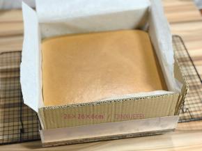 出锅后，先取下硬纸板，然后提起油纸把蛋糕提到晾网上