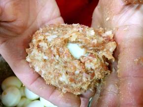 用双手轻轻的将肉馅把鸡蛋裹上。