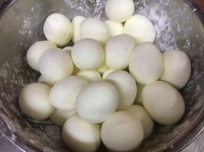 放入干淀粉，把鸡蛋摇一摇，让鸡蛋裹上一层薄薄的干淀粉。 这一步的目的是为了让鸡蛋能牢牢的和肉馅粘合在一起，避免炸的时候鸡蛋脱落。