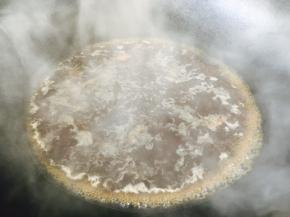 将炖龙眼丸子的汤汁倒入锅里，煮开。