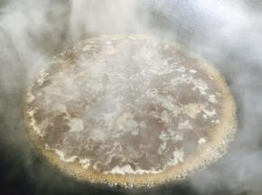将炖龙眼丸子的汤汁倒入锅里，煮开。