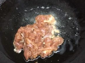 锅里倒入适量的油烧热后，将肉放入划开，炒到变色
