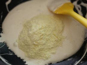分两次加入奶粉，将它们拌匀。