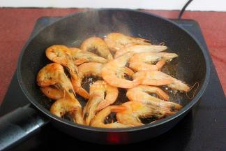 热锅倒油，放入腌制好的虾，煎炸至变黄色，说明虾已经熟了，起锅；