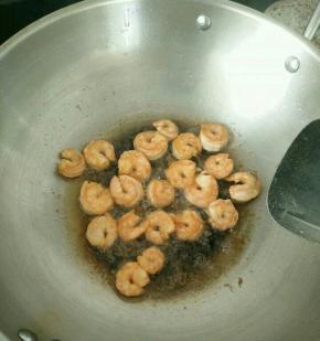 热锅凉油下虾仁，煎至两面金黄。