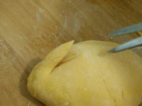 用剪刀在小的那头一侧，剪一刀。