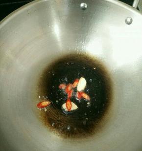 锅烧热放适量油，下辣椒和蒜头爆香。