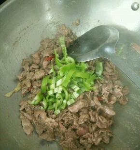 牛肉变色马上加入辣椒条，翻炒均匀。