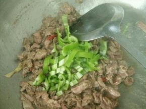 牛肉变色马上加入辣椒条，翻炒均匀。