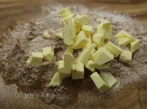 从冰箱取出黄油，切成小块，放在面粉上。