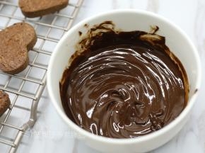 接着我们来准备夹心。巧克力和黄油切成小块，隔水加热到融化，搅拌到两者混合均匀。