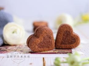 用卡纸剪出一个比饼干略小的心形，放在饼干上，撒上可可粉，取下卡纸，这样，简单又好看的心形巧克力夹心饼干就做好了。