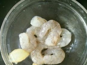 鲜虾去皮，挑去虾线和虾肠。加入少许盐、姜片和几滴料酒，腌一下。