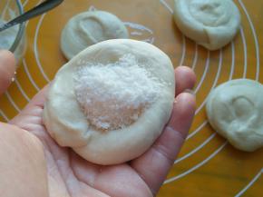 每段小面团，竖着按扁，加入白糖馅，包好