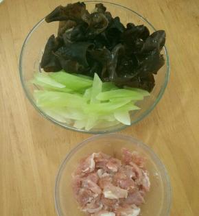 莴笋去皮切成片，云耳泡好摘去蒂。猪肉切成片，用料酒、生抽和盐盐十分钟。
